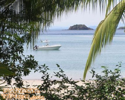[Hermoso paisaje visto desde la costa de Coiba. Se observa un bote de los muchos que visitan este destino turístico.]